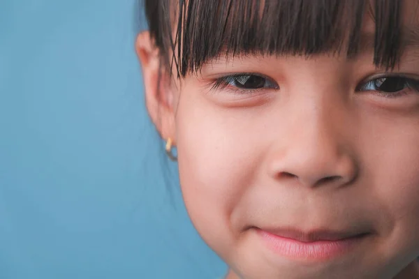 笑顔の少女の肖像画は カメラを見て 閉じるアップかわいいですアジアの女の子顔ポーズ上の青の背景 — ストック写真