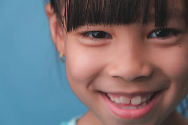 笑顔の少女の肖像画は カメラを見て 閉じるアップかわいいですアジアの女の子顔ポーズ上の青の背景 — ストック写真