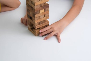 Tatlı Asyalı kardeşler birlikte Jenga oynarken eğleniyorlar. Evde, masada Jenga oyunu oynayan iki çocuk. Tahta bulmacalar çocuklar için zekayı artıran oyunlardır. Çocuklar için eğitici oyuncaklar.