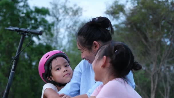 母亲和孩子们在公园里骑完摩托车后 坐着休息 母亲和女儿们都有时间一起在户外骑摩托车 快乐爱的家庭 — 图库视频影像