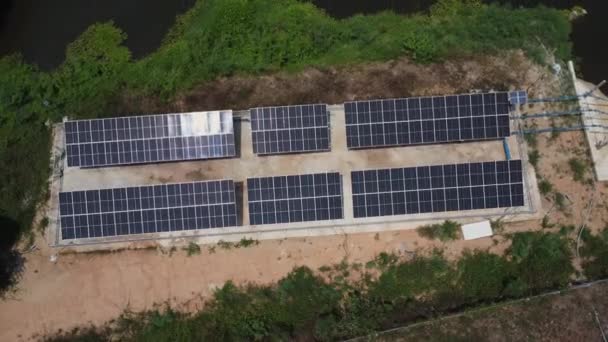 太陽光発電パネルのトップビュー きれいなエネルギー又は太陽エネルギーから川の近くの灌漑のための水ポンプ 農業機器と太陽電池パネルのドローンの空中ビュー — ストック動画