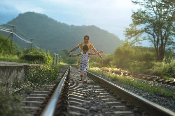 엄마와 귀여운 있습니다 과푸른 초목을 배경으로 철도를 — 스톡 사진