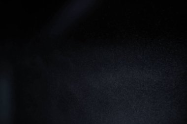 Karanlık arka planda su tozu. Sprey etkisi siyah arkaplanda izole edildi.