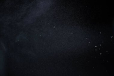 Karanlık arka planda su tozu. Sprey etkisi siyah arkaplanda izole edildi.