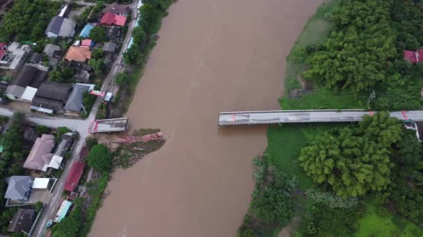 洪水がアスファルトを洗い流した後 川を渡る破損した道路橋の空中観察 雨季のフラッシュフラッシュ後のブリッジ — ストック動画