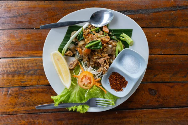 Kızarmış pirinç eriştesi, soya sosu, domuz eti ve lahana. Tayland yemeği (Pad See Ew)