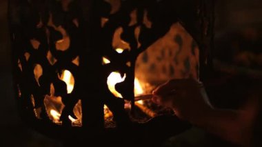 Asyalılar, Tayland 'daki geleneksel Songkran festivalinde dilek tutmak için tapınakta Buda' ya hürmetlerini sunmaya mum yakıyorlar..