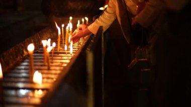 Asyalılar, Tayland 'daki geleneksel Songkran festivalinde dilek tutmak için tapınakta Buda' ya hürmetlerini sunmaya mum yakıyorlar..
