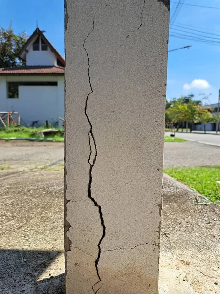 Hasarlı yapı sütunlarında çatlaklar var. Eski bir evin çatlamış beton sütunları. Eski bir beton sütunun ön yüzeyinde derin ve berrak çatlaklar var..