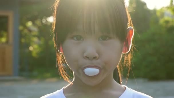 Sevimli Küçük Kız Sakız Yemekten Gün Işığında Arka Bahçede Köpük — Stok video