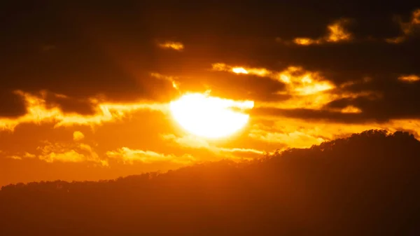 Closeup of bright big sun on the sky with orange gradient colors in a calmly evening.