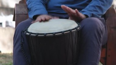 Asyalı adam ritmik enstrüman çalıyor. Bir adam bir partide uzun bir davul çalar. Tayland müzik aletleri