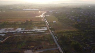 Baharda gün doğumunda güzel pirinç tarlası manzarası ve etrafında kuşlar uçuşuyor. Tayland kırsalına ekmeden önce pirinç tarlalarının havadan görünüşü.