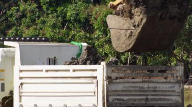 Kurak mevsimde tarım için kullanılmak üzere bir su birikintisi inşa etmek için bir çöp kamyonuna toprak kazmak. Bir kepçenin havadan görünümü işe yarıyor.