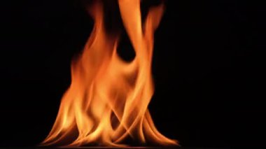 Siyah arka planda sıcak alevler. Karanlıkta güzel bir ateş alevi. Yanan alevler ve duman soyutu.