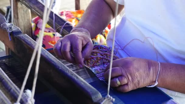 職場の古典的なアジア織物に多様な明るい糸でタペストリーを織る手のクローズアップ タイ北部の山岳部族の伝統的な手織り — ストック動画