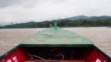 Mekong Nehri 'nde doğa ve Lao köyleri manzaralı yerel bir yolcu gemisinin görüntüsü..