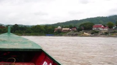 Mekong Nehri 'nde doğa ve Lao köyleri manzaralı yerel bir yolcu gemisinin görüntüsü..