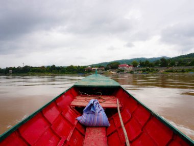 Mekong Nehri 'nde doğa ve Lao köyleri manzaralı yerel bir yolcu gemisinin görüntüsü..