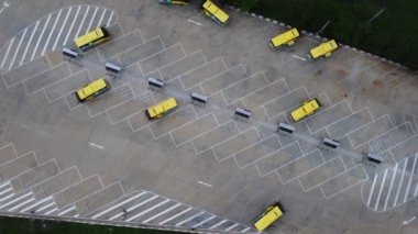Elektrik otobüs şarj istasyonunun hava görüntüsü. Sarı elektrikli otobüs şarj kablosuyla şarj oluyor. Elektrikli taşıma gelecekteki taşınabilirlik e-hareketi.
