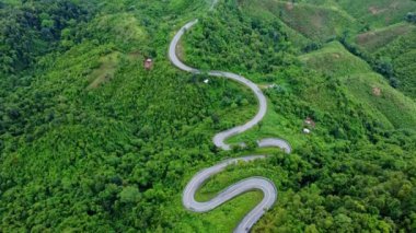 Ormanın ortasındaki bir yolun havadan görünüşü, Kuzey Tayland 'da dağlarda kıvrımlı bir yol inşaatı..