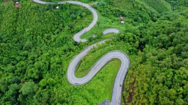 Ormanın ortasındaki bir yolun havadan görünüşü, Kuzey Tayland 'da dağlarda kıvrımlı bir yol inşaatı..