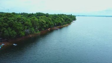 Kham Somboon Sahili, Bueng Khong Bölgesi, Bueng Kan Eyaleti, Tayland, doğada zengin olan büyük bir su kütlesini çevreleyen ormanın doğasını gösteriyor..