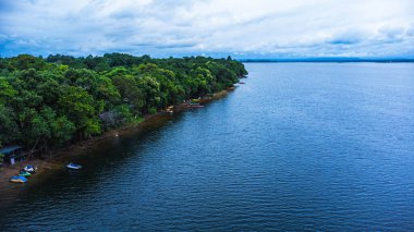 Kham Somboon Sahili, Bueng Khong Bölgesi, Bueng Kan Eyaleti, Tayland, doğada zengin olan büyük bir su kütlesini çevreleyen ormanın doğasını gösteriyor..