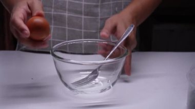 Genç bayan mutfakta aşama aşama omlet yapıyor.