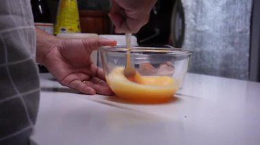 Genç bayan mutfakta aşama aşama omlet yapıyor.