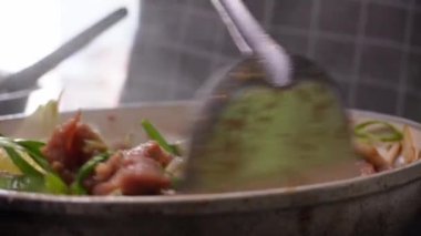 Genç bir kadın mutfakta adım adım domuz sukiyaki pişiriyor..