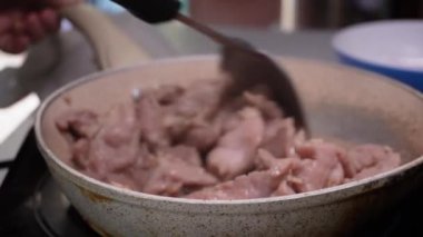 Genç bir kadın mutfakta adım adım domuz sukiyaki pişiriyor..