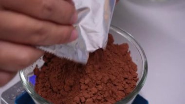 Genç kadın mutfakta ev yapımı brovni yapıyor, adım adım pişiriyor..