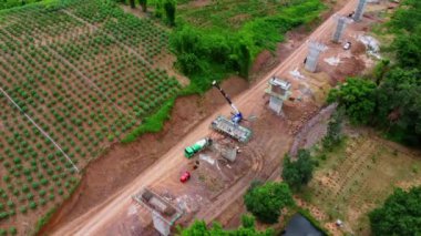 Yeni bir yol ya da otoyol inşaatının havadan görüntüsü. Dağların ortasındaki yol yapım işçilerinin üzerindeki bir dronun üst görüntüsü. Vinçler ve Ağır Ekipmanlı İnşaat Alanı.