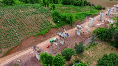 Yeni bir yol ya da otoyol inşaatının havadan görüntüsü. Dağların ortasındaki yol yapım işçilerinin üzerindeki bir dronun üst görüntüsü. Vinçler ve Ağır Ekipmanlı İnşaat Alanı.
