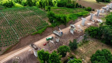 Yeni bir yol ya da otoyol inşaatının havadan görüntüsü. Dağların ortasındaki yol yapım işçilerinin üzerindeki bir dronun üst görüntüsü. Vinçler ve Ağır Ekipmanlı İnşaat Alanı.