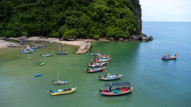 Geleneksel renkli Taylandlı eski ahşap balıkçı teknelerinin alçak gelgit sırasında insansız hava aracı görüntüsü. Geleneksel Tayland uzun kuyruklu balıkçı tekneleri tropikal denizde