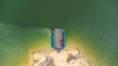 Yerel feribot, araba, motosiklet ve insanların Kanchanaburi Eyaleti, Tayland 'daki bir nehri geçişlerinin hava görüntüsü..