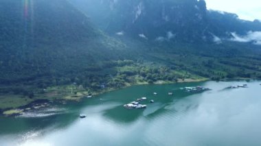 Kanchanaburi, Tayland 'da güzel bir göl kenti manzarası. Arkasında dağlar ve sabah sisi var..