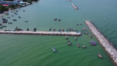 Geleneksel renkli Taylandlı eski ahşap balıkçı teknelerinin alçak gelgit sırasında insansız hava aracı görüntüsü. Geleneksel Tayland uzun kuyruklu balıkçı tekneleri tropikal denizde