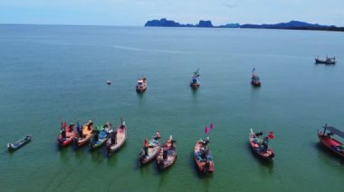 Geleneksel renkli Taylandlı eski ahşap balıkçı teknelerinin alçak gelgit sırasında insansız hava aracı görüntüsü. Geleneksel Tayland uzun kuyruklu balıkçı tekneleri tropikal denizde