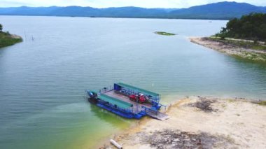 Yerel feribot, araba, motosiklet ve insanların Kanchanaburi Eyaleti, Tayland 'daki bir nehri geçişlerinin hava görüntüsü..