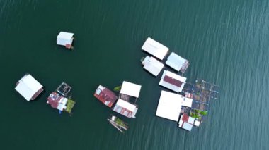 Kwai Nehri 'nin havadan görünüşü ve Kanchanaburi Eyaleti, Tayland' da yüzen evler. Yüzen kulübelerin ve Kwai Nehri üzerinde yüzen Tayland uzun kuyruklu teknelerinin güzel manzarası..