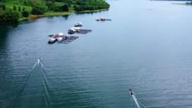 Kwai Nehri 'nin havadan görünüşü ve Kanchanaburi Eyaleti, Tayland' da yüzen evler. Yüzen kulübelerin ve Kwai Nehri üzerinde yüzen Tayland uzun kuyruklu teknelerinin güzel manzarası..