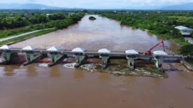 Yağmur mevsiminde barajın baraj kapaklarının hızlı su akışını gösteren hava manzarası. Baraj suyu boşaltımı, sağanak yağmurdan sonra baraj aşırı doluluk.