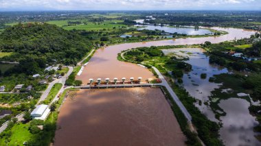 Yağmur mevsiminde barajın baraj kapaklarının hızlı su akışını gösteren hava manzarası. Baraj suyu boşaltımı, sağanak yağmurdan sonra baraj aşırı doluluk.