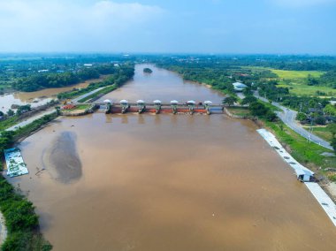 Yağmur mevsiminde barajın baraj kapaklarının hızlı su akışını gösteren hava manzarası. Baraj suyu boşaltımı, sağanak yağmurdan sonra baraj aşırı doluluk.