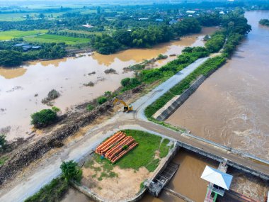 Toprak kaymaları ve kazıcıların çalıştığı doğal afetler. Selin yol açtığı doğal afetler nehir boyunca uzanan yol yüzeyini tahrip etti..