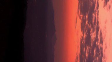 Turuncu gökyüzünde tüylü bulutlarla güzel bir günbatımı zamanı atlaması. Sıcak romantik gökyüzü ve güneş doğarken bulutlar. kış gökyüzü.