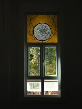 Kilisedeki beyaz pencereler boyalı camlarla süslenmiş..